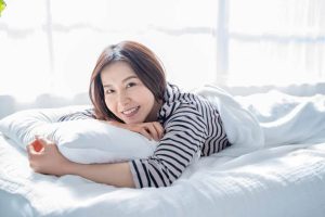 Woman sleeping peacefully on LOFE organic buckwheat pillow with perfect neck alignment