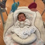 Cozy newborn in padded Ingenuity baby swing with gentle vibration feature