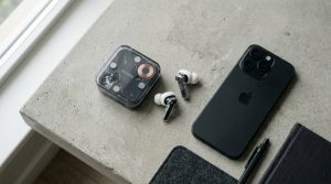 Transparent Nothing earbuds and charging case resting on a minimalist concrete desk.