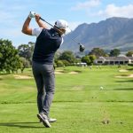 Man wearing a stylish gray golf vest on a golf course.